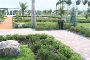 Environmental pavement made of orange clay next to brick paver memorial