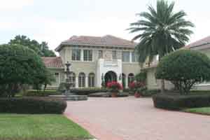 A residential landscaping project in Lake Butler Sound, Windermere Florida with palms and groundcover and fountain