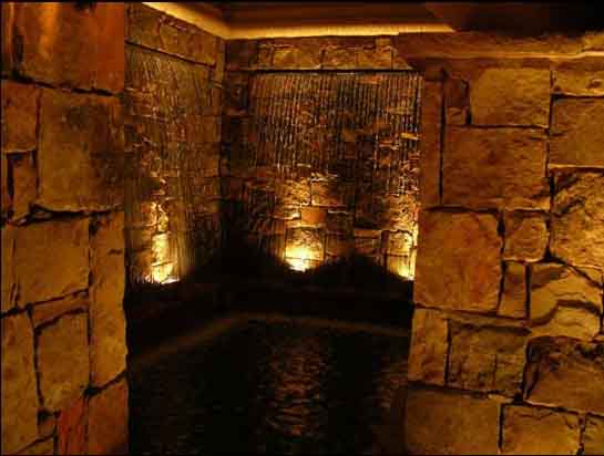 stone wall with fountain lighting shining from below and wall wash techniques on other portions of this fountain in Orlando Florida